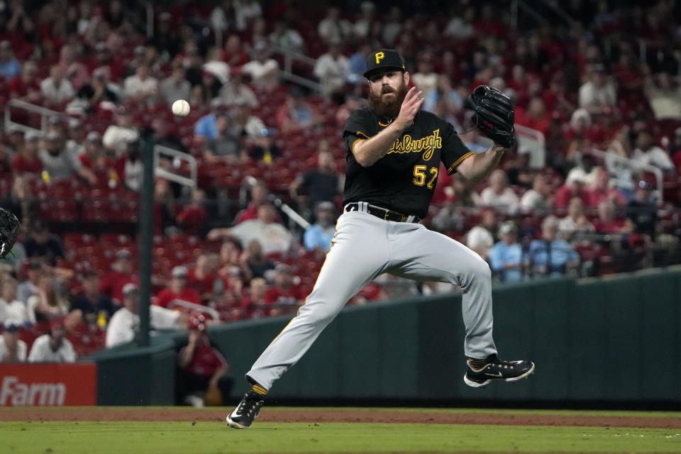 Pittsburgh Pirates relief pitcher Colin Selby commits an error trying to throw out St. Louis Cardinals' Tommy Edman at first during the ninth inning of a baseball game Friday, Sept. 1, 2023, in St. Louis. Edman reached base and went on to second on the error. (AP Photo/Jeff Roberson)