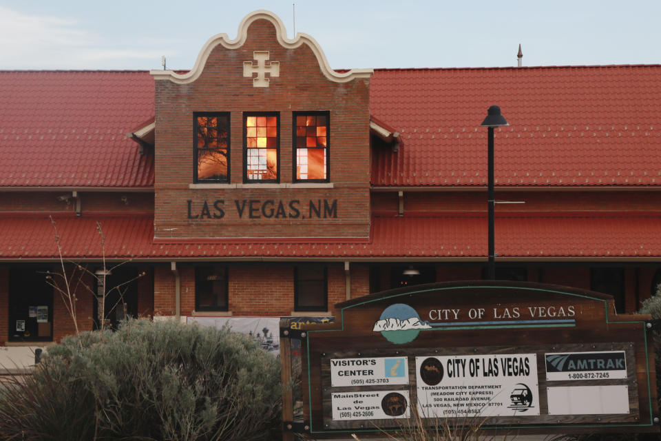 Reddened by wildfire smoke, the sun is seen reflected off windows at the train station in Las Vegas, N.M., on Saturday, May 7, 2022. Area residents have been on and off of evacuation orders of the past month as fires grow and move with intense and unpredictable winds. (AP Photo/Cedar Attanasio)