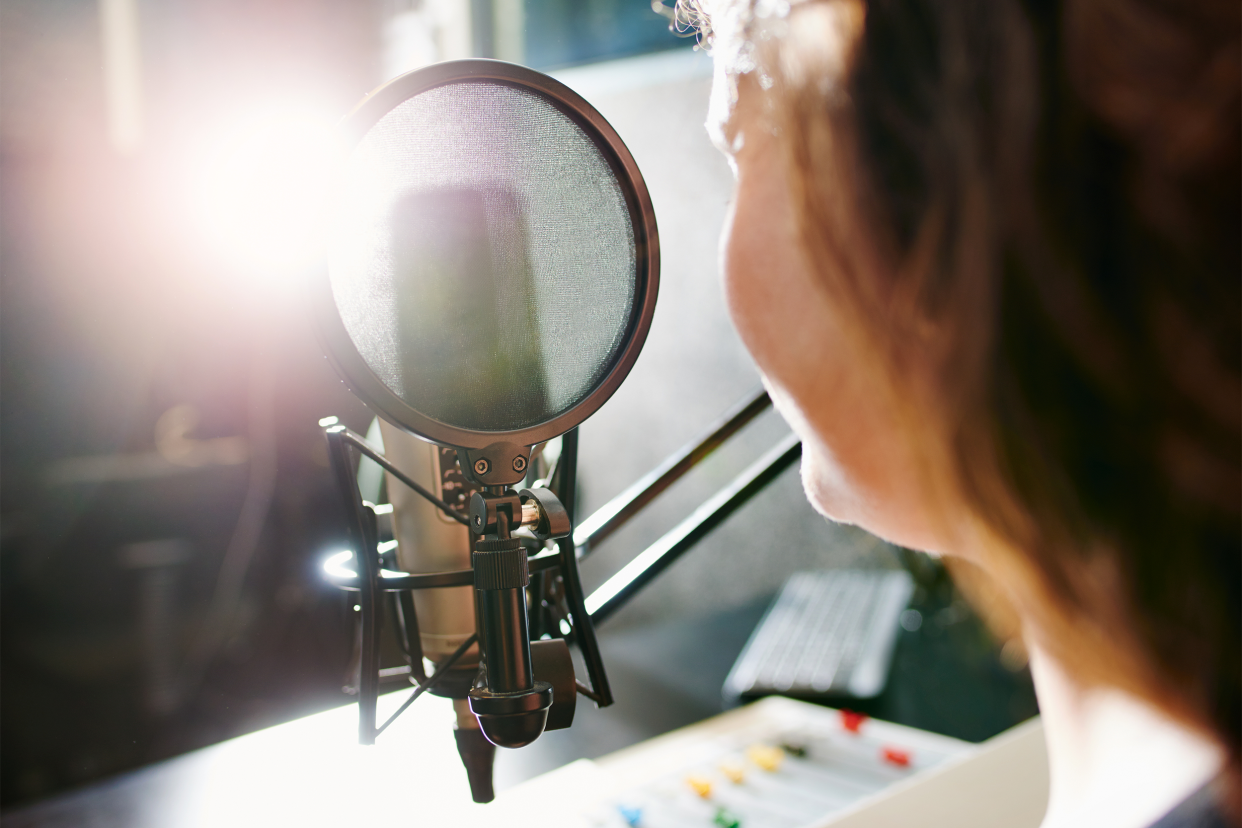 Closeup of woman speaking into a microphone in a studio