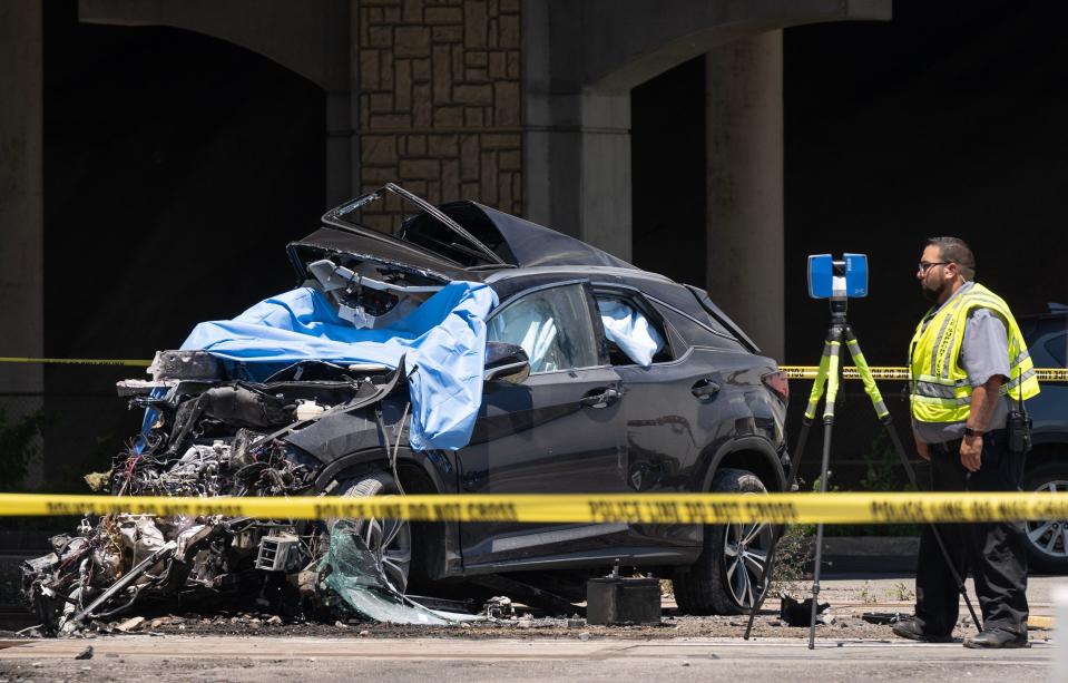 An investigator looks at an SUV that was smashed Wednesday in a collision with a train, killing the SUV's driver.