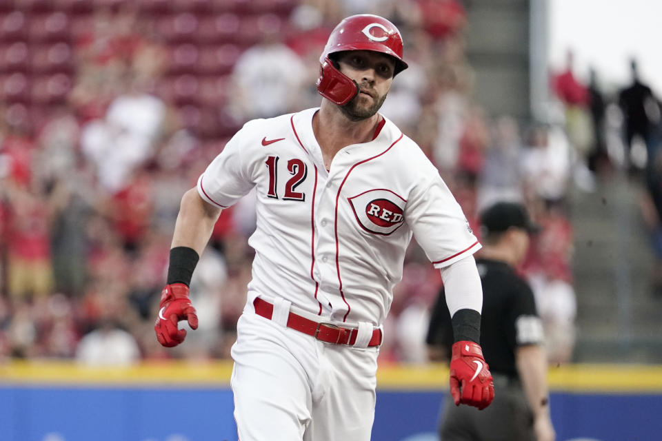 Cincinnati Reds' Tyler Naquin (12) runs to third base after hitting a triple during the first inning of a baseball game against the Miami Marlins Friday, Aug. 20, 2021, in Cincinnati. (AP Photo/Jeff Dean)