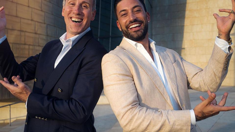 Anton Du Beke posing in suit with Strictly professional Giovanni Pernice