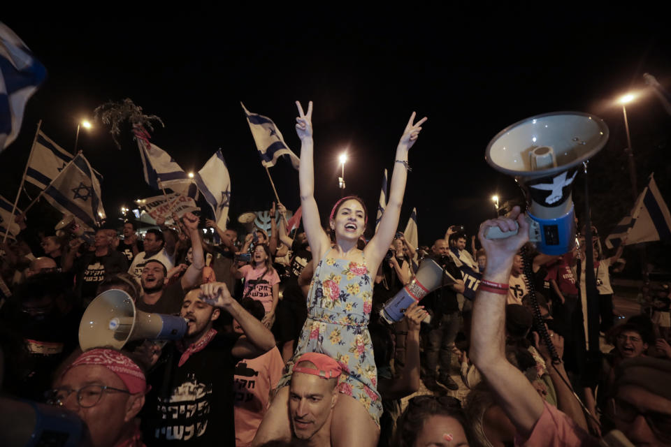 Israelis celebrate the swearing in of the new government in Jerusalem, Sunday, June 13, 2021. Israel's parliament has voted in favor of a new coalition government, formally ending Prime Minister Benjamin Netanyahu's historic 12-year rule. Naftali Bennett, a former ally of Netanyahu, became the new prime minister. (AP Photo/Sebastian Scheiner)