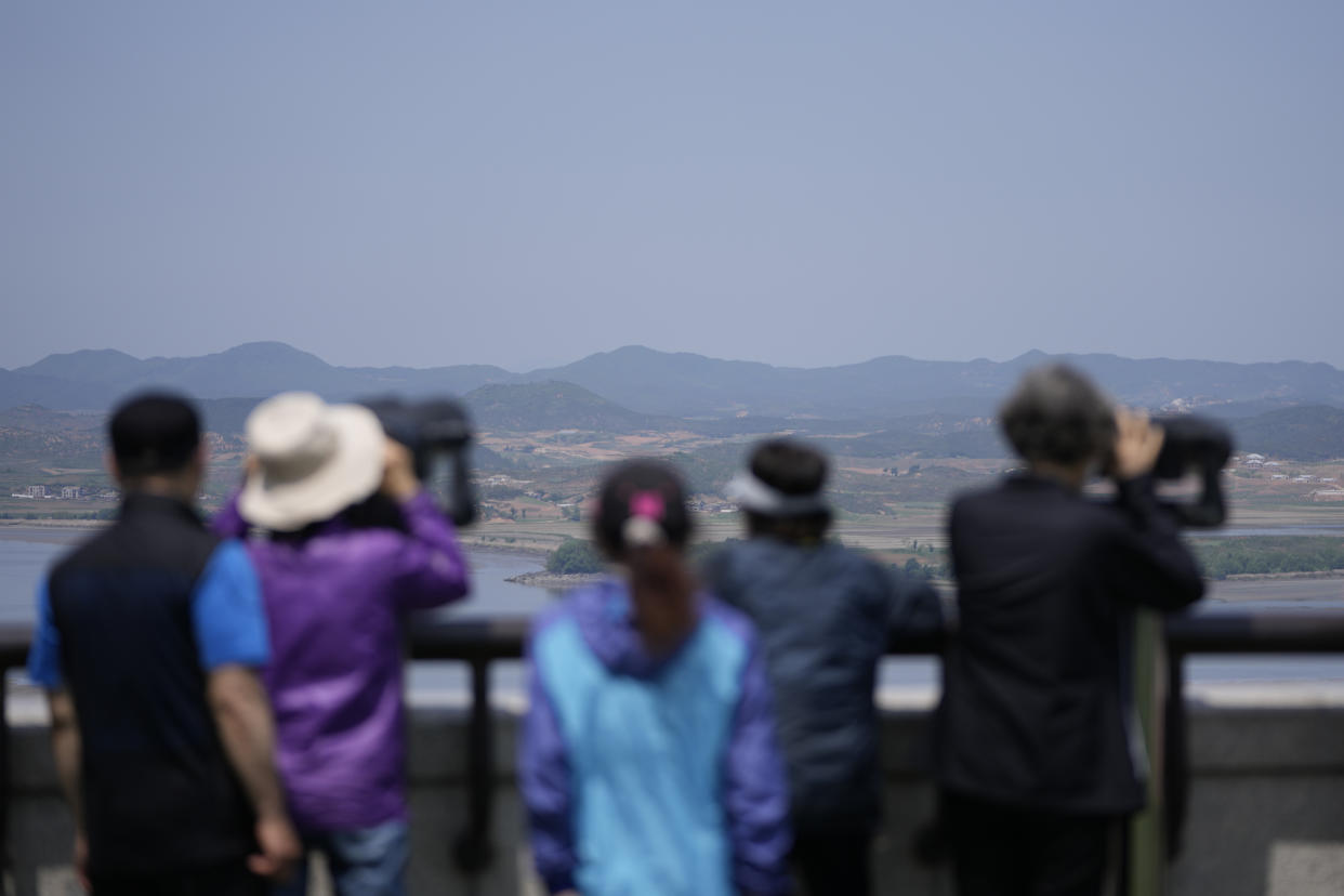 Visitors use binoculars to see the North Korean side from the unification observatory in Paju, South Korea, Thursday, May 12, 2022. North Korea imposed a nationwide lockdown Thursday to control its first acknowledged COVID-19 outbreak after holding for more than two years to a widely doubted claim of a perfect record keeping out the virus that has spread to nearly every place in the world. (AP Photo/Lee Jin-man)