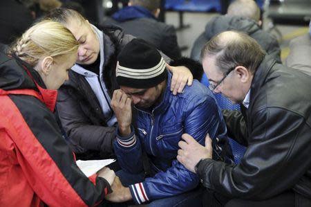 A psychologist of the Russian Emergencies Ministry (L) speaks with a relative (C) of a victim of the crashed Flydubai Boeing 737-800 at the airport of Rostov-On-Don, Russia, March 19, 2016. REUTERS/Sergei Pivovarov