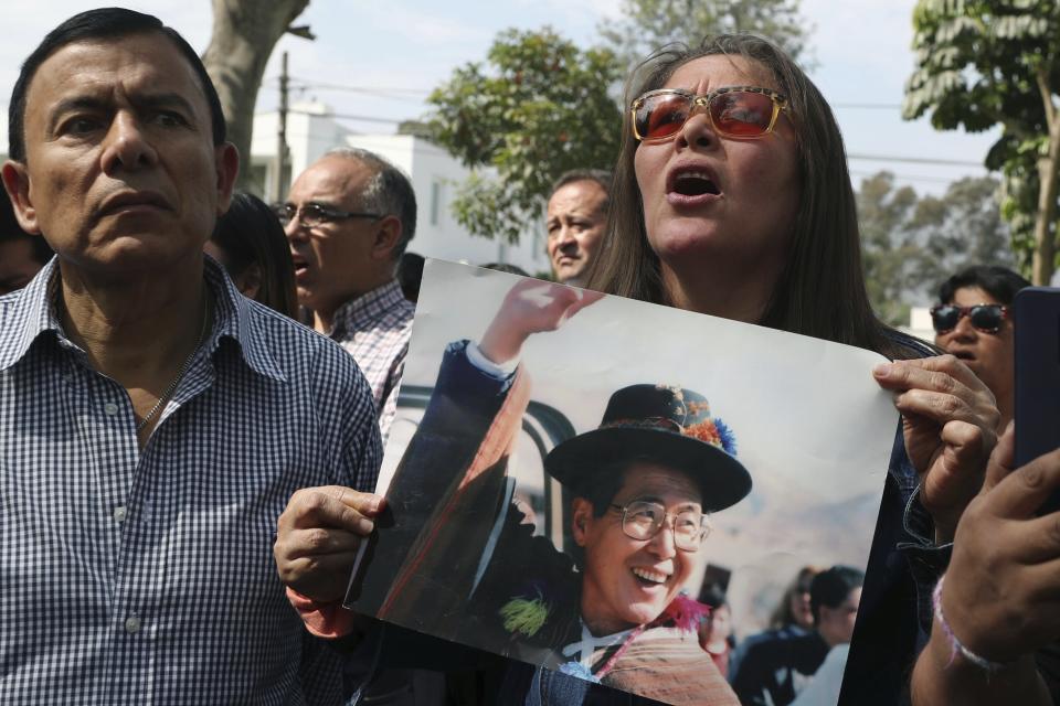 Supporters of Peru’s former President Alberto Fujimori shout slogans as they hold photos of him, outside Fujimori's home in Lima, Peru, Wednesday, Oct. 3, 2018. Peru's Supreme Court has overturned a medical pardon for former President Alberto Fujimori and ordered the strongman be returned to jail to serve out a long sentence for human rights abuses. (AP Photo/Martin Mejia)