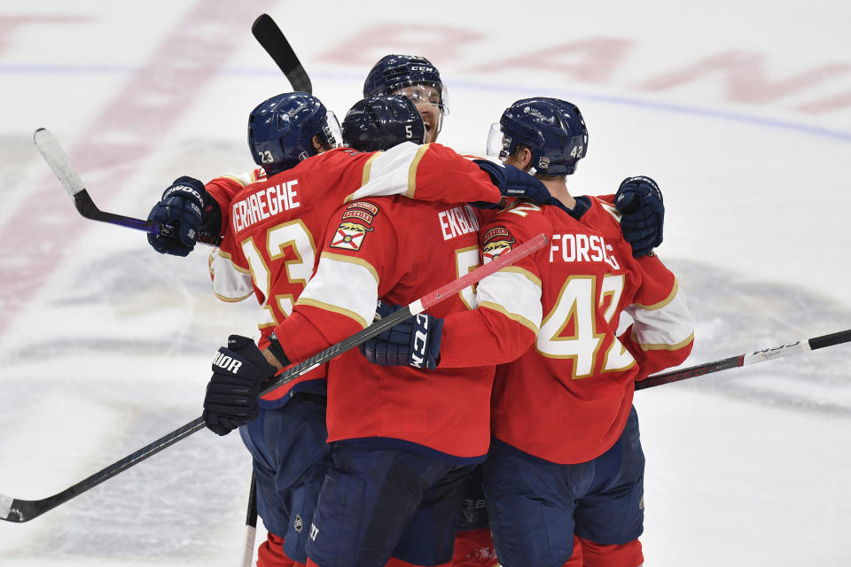 Florida Panthers defenseman Aaron Ekblad (5) is congratulated by his teammates after scoring during the third period of Game 2 of the NHL hockey Stanley Cup Finals against the Edmonton Oilers, Monday, June 10, 2024, in Sunrise, Fla. (AP Photo/Michael Laughlin)