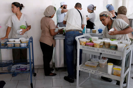 Waitresses of the J.M. de los Rios Children Hospital wait for cups of soup donated by La Casa Bistro restaurant, member of the "Full Stomach, Happy Heart" (Barriga llena, corazon contento) charity, to distribute them at hospitalization floors, in Caracas, Venezuela February 20, 2017. REUTERS/Marco Bello