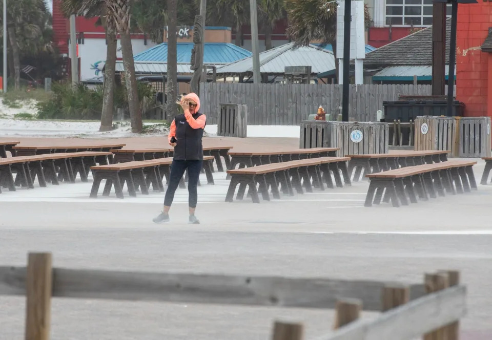 Mihaela Girbacica, of Omaha, Nebraska, braces against the strong wind at Casino Beach as a storm approaches the Pensacola area on April 10, 2024.