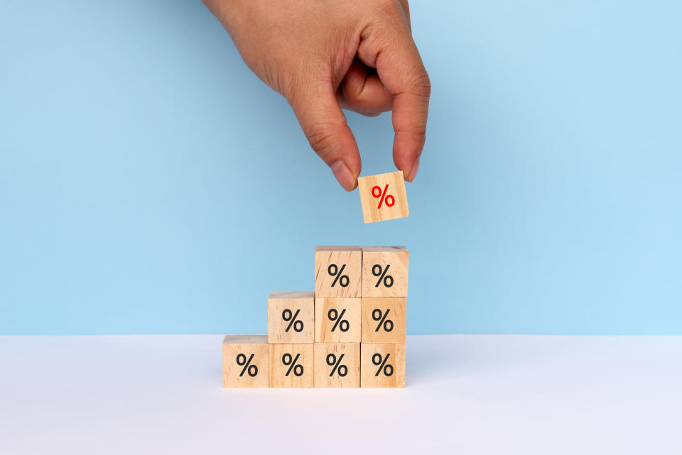 a hand stacking blocks with percentages stamped on them