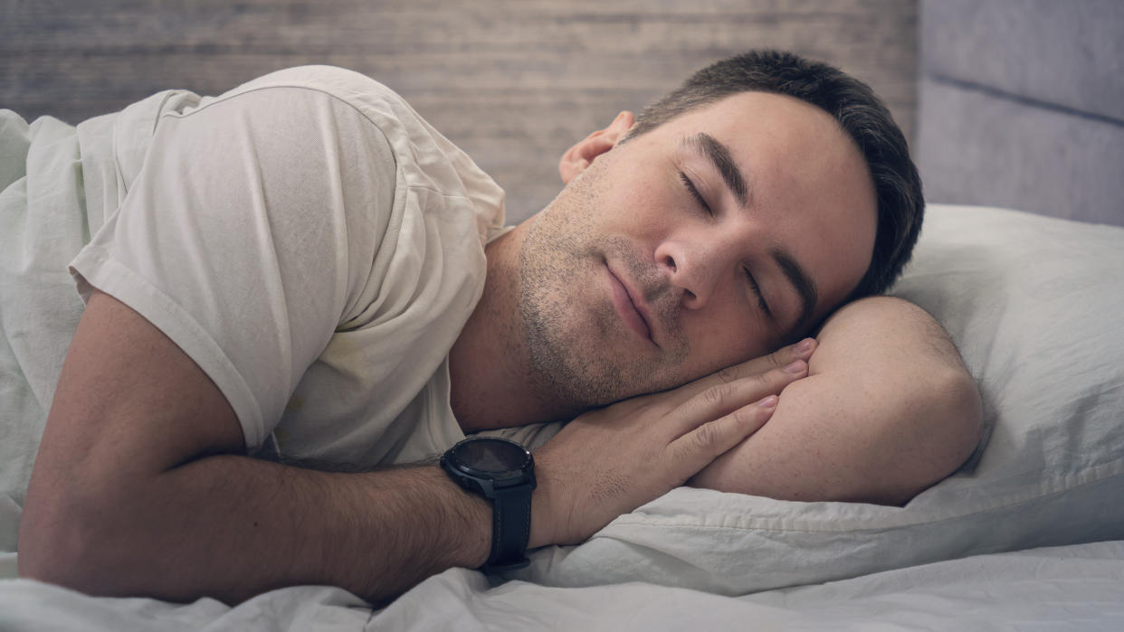  Sleeping man wearing sports watch. 