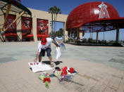 Los Angeles Angels fan Steven Beltran adds to a make-shift memorial at Angels Stadium in Anaheim, Calif., for pitcher Tyler Skaggs, who died Monday at the age of 27, in Texas, stunning Major League Baseball and leading to the postponement of the team's game against the Texas Rangers Monday, July 1, 2019. (AP Photo/Alex Gallardo)