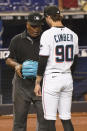 MLB umpire Laz Diaz checks the glove of Miami Marlins relief pitcher Adam Cimber (90) during the sixth inning of a baseball game against the Toronto Blue Jays, Wednesday, June 23, 2021, in Miami. (AP Photo/Marta Lavandier)