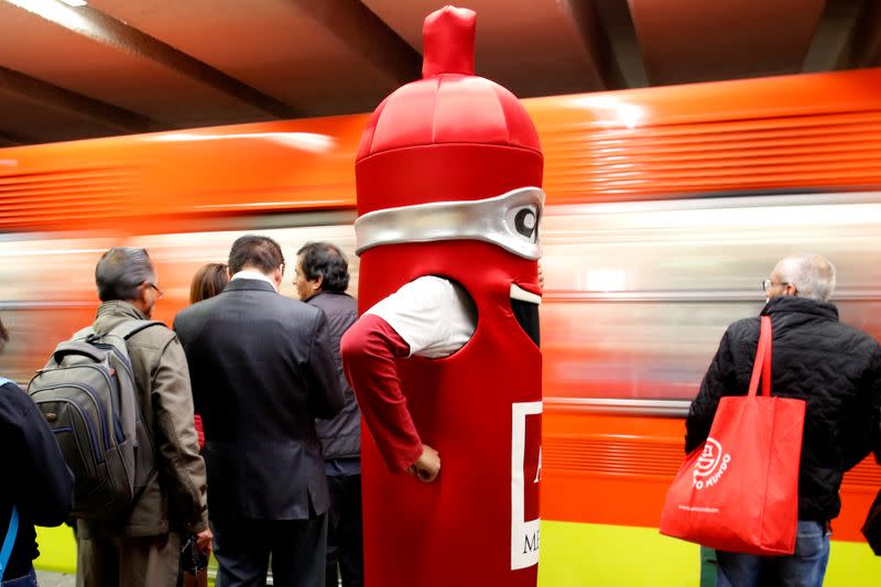 A man wearing a costume, representing a condom, is seen at a metro station, on the International Condoms Day, celebrated a day before Valentine Day, in Mexico City