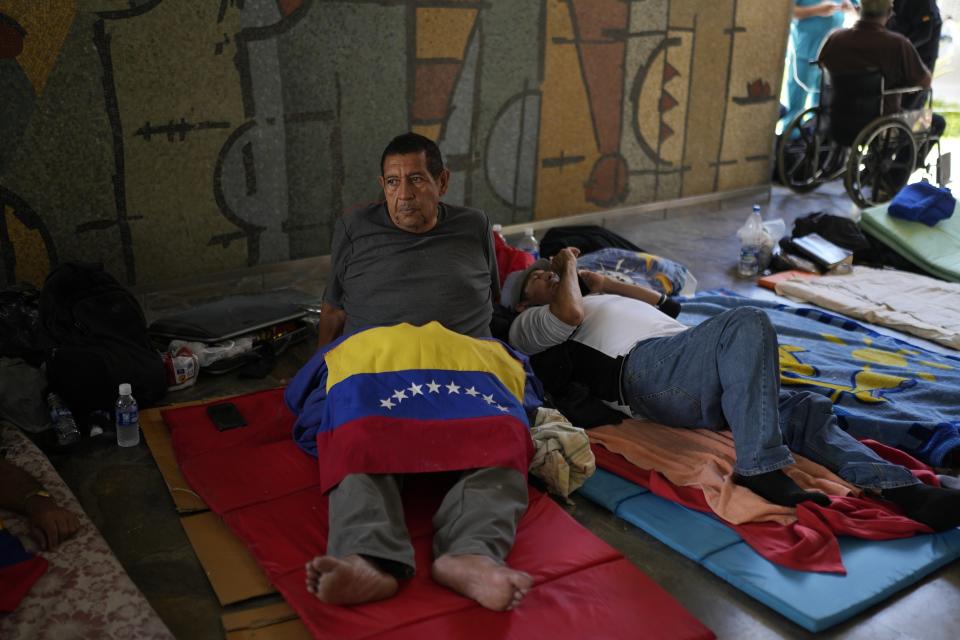 FILE - Rodolfo Hernandez, 67, who retired from the Venezuelan state oil company PDVSA after working there for 37 years, lies on the ground covered with a Venezuelan flag during a week-long hunger strike alongside other PDVSA retirees to demand pension and back salary payments, at the Central University of Venezuela (UCV, File) in Caracas, Venezuela, Oct. 3, 2023. (AP Photo/Ariana Cubillos, File)