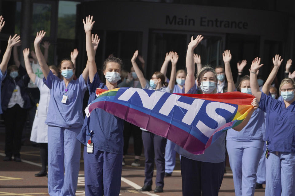 NHS staff outside Royal Victoria Infirmary join in the pause for applause to salute the NHS 72nd birthday, in Newcastle, England, Sunday, July 5, 2020. People across the U.K. joined a round of applause to celebrate the 72nd anniversary of the formation of the free-to-use National Health Service, undoubtedly the country’s most cherished institution. The reverence with which it is held has been accentuated this year during the coronavirus pandemic. (Owen Humphreys/PA via AP)