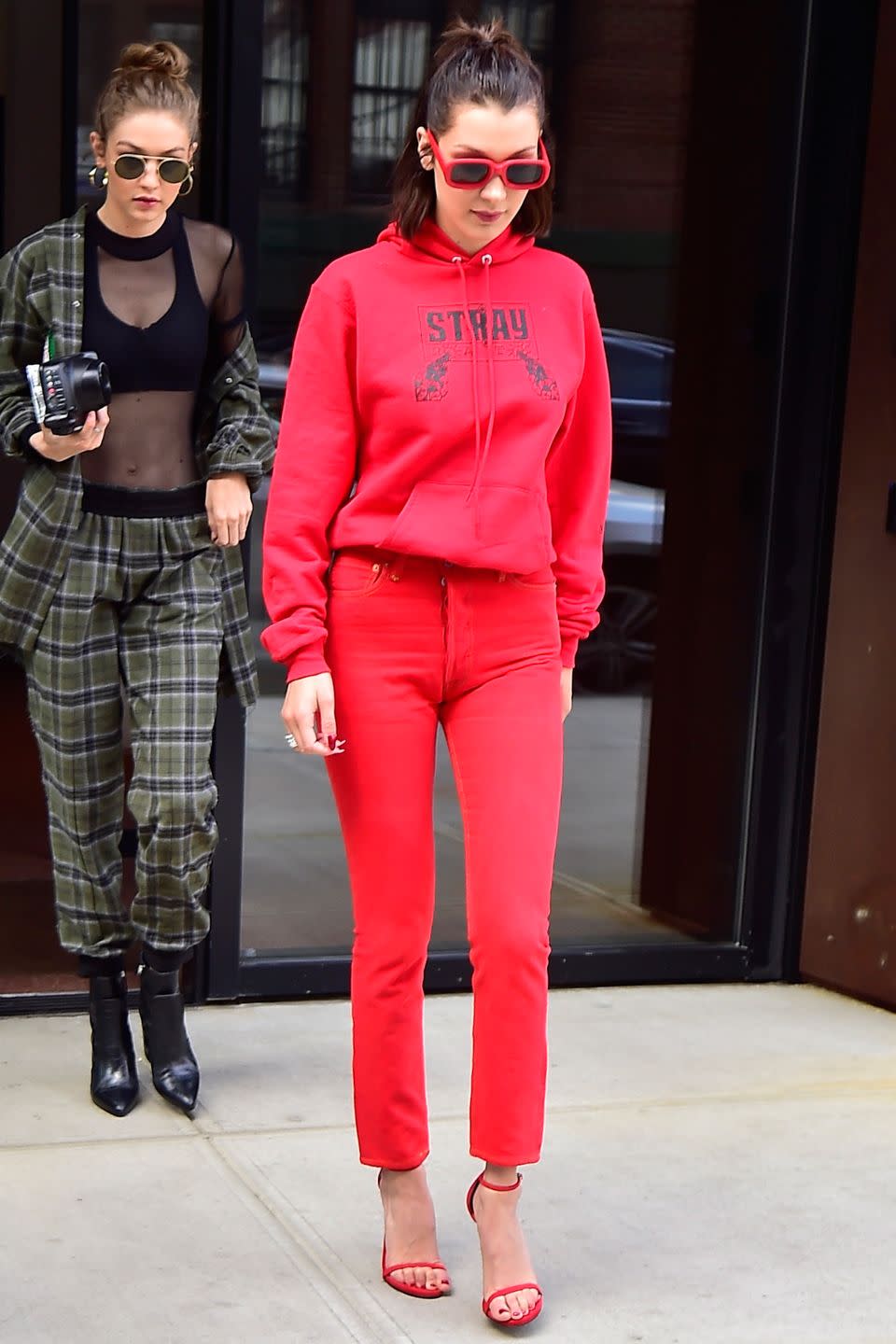 <p>In a red hoodie, jeans, heeled sandals and sunglasses while out in New York with sister Gigi Hadid.</p>