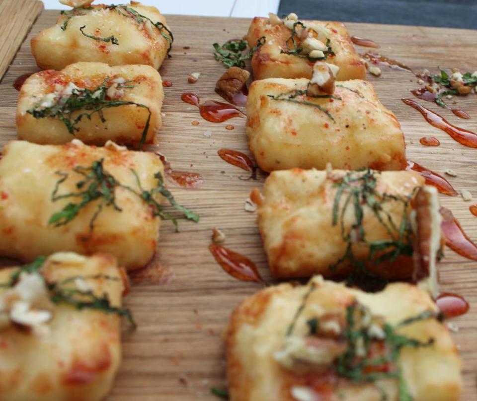 A sampling of Crispy Halloumi, a Greek grilling cheese, topped with pecans and watermelon molasses.