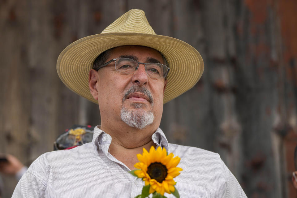 FILE - Seed Movement presidential candidate Bernardo Arevalo holds a sunflower during a campaign rally in Santa Maria de Jesus, Guatemala, July 16, 2023. The 64-year-old academic and former diplomat won just 11% of the vote in the June 25th presidential election's first round, but it was enough to give him the second slot in the Aug. 20 runoff ballot. (AP Photo/Moises Castillo, File)