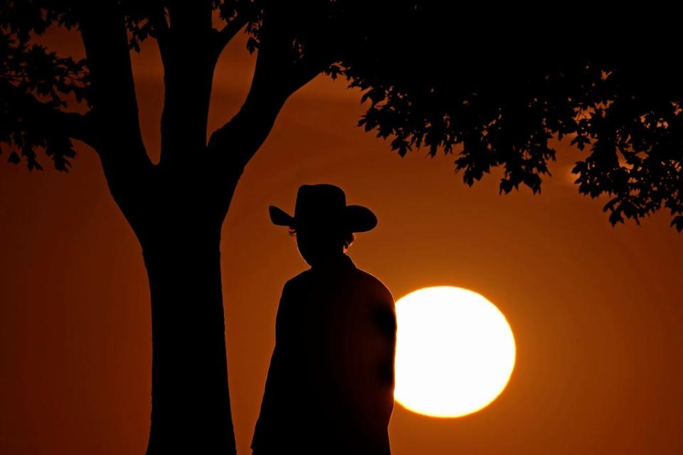 A man watches the last sunset of daylight saving time, Saturday, Nov. 6, 2021, in Kansas City, Mo. The sun will set an hour earlier Sunday as people in most of the United States set their clocks back an hour to switch to standard time.