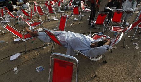 A supporter of Imran Khan, cricketer-turned-opposition politician and chairman of the Pakistan Tehreek-e-Insaf (PTI) political party, sleeps on chairs early in the morning during the Freedom March in Islamabad August 18, 2014. REUTERS/Akhtar Soomro