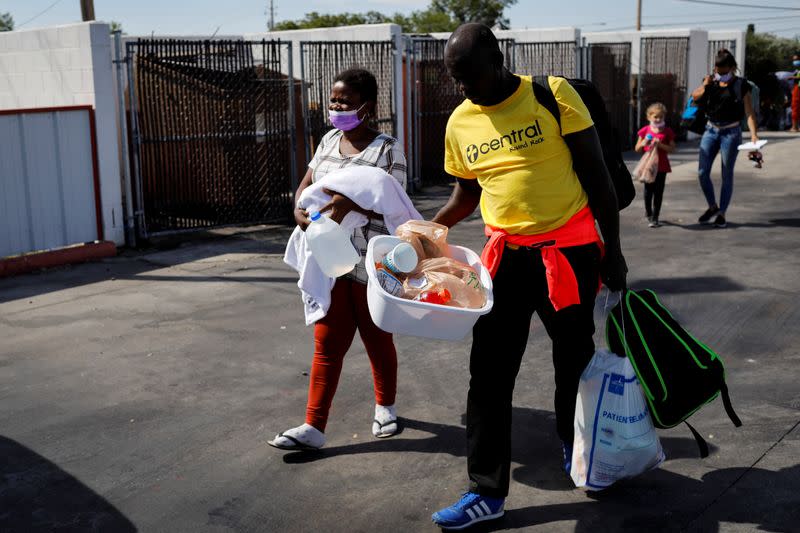 Migrants seeking asylum in the U.S. walk towards a bus to San Antonio at a gas station after being released from U.S. Customs and Border Protection, in Del Rio