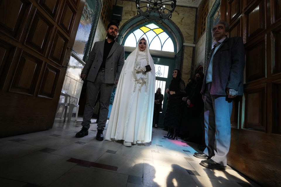 A groom and bride arrive at a polling station to vote for the parliamentary and Assembly of Experts elections, in Tehran, Iran, Friday, March 1, 2024. Iran began voting Friday in its first elections since the mass 2022 protests over its mandatory hijab laws after the death of Mahsa Amini, with questions looming over just how many people will turn out for the poll. (AP Photo/Vahid Salemi)