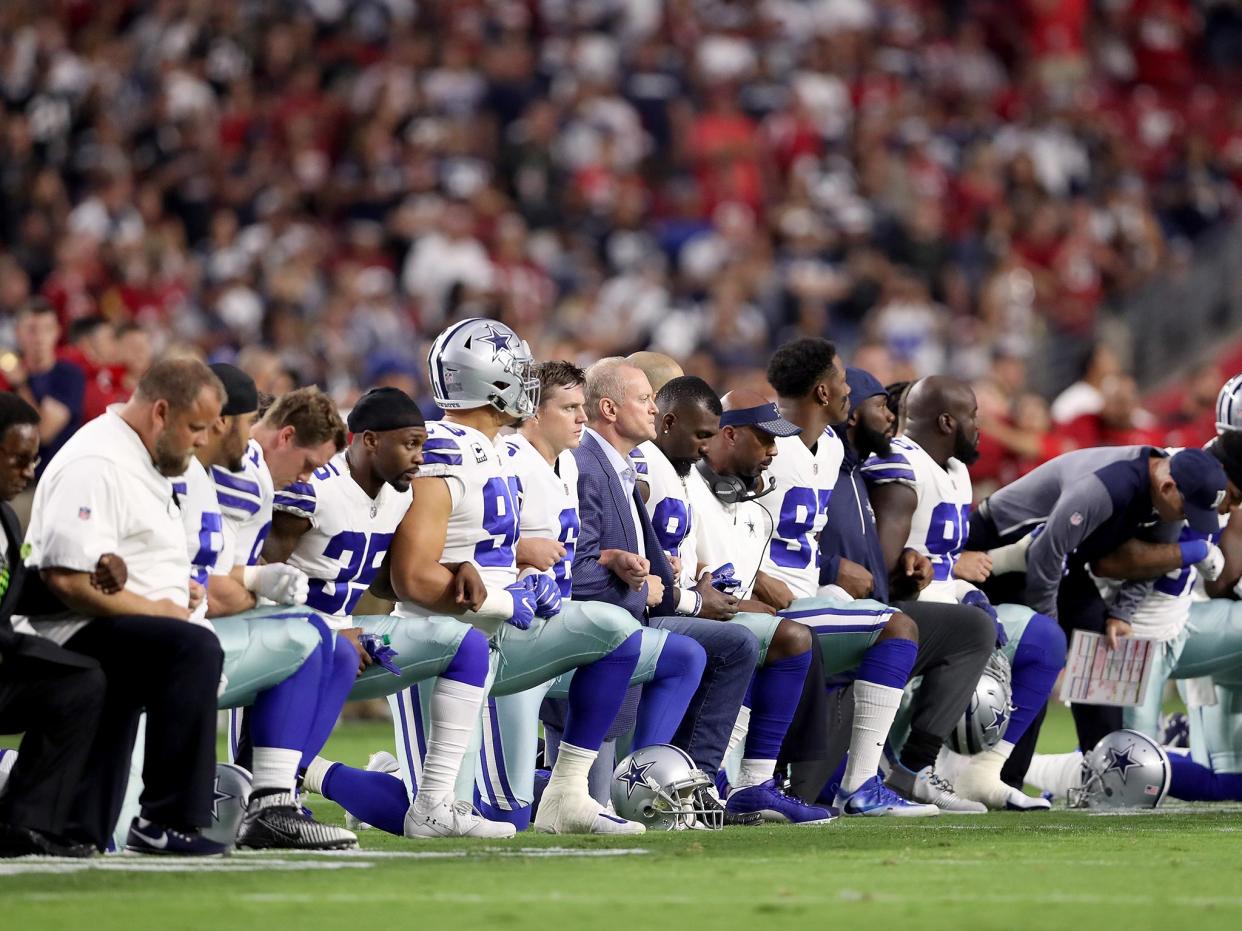 Members of the Dallas Cowboys link arms before the start of their NFL game against the Arizona Cardinals: Getty