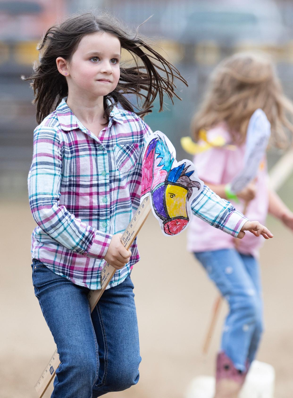 Everly Burke, 5, of Carrollton heads for the finish line to win her heat in the kids Stick Horse race at the Minerva Chamber Rodeo.