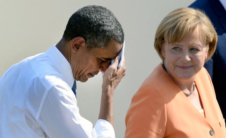 File picture taken on June 19, 2013 shows US President Barack Obama wiping his brow as he and German Chancellor Angela Merkel leave the stage after his speech at the Brandenburg Gate in Berlin