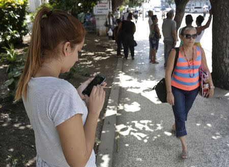 A woman uses the internet via public Wi-Fi in Havana July 2, 2015. REUTERS/Enrique de la Osa