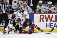Chicago Blackhawks defenseman Connor Murphy (5) and New Jersey Devils center Pavel Zacha (37) battle for the puck during the first period of an NHL hockey game Friday, Oct. 15, 2021, in Newark, N.J. (AP Photo/Adam Hunger)