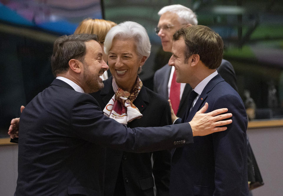 European Central Bank President Christine Lagarde, center, speaks with Luxembourg's Prime Minister Xavier Bettel, left, and French President Emmanuel Macron, right, during a round table meeting at an EU summit in Brussels, Friday, Dec. 13, 2019. European Union leaders are gathering Friday to discuss Britain's departure from the bloc amid some relief that Prime Minister Boris Johnson has secured an election majority that should allow him to push the Brexit deal through parliament. (AP Photo/Olivier Matthys)