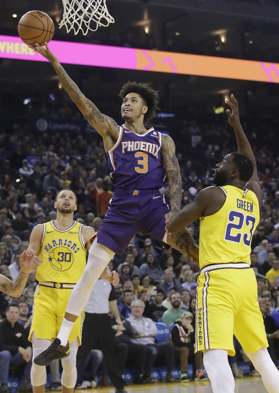 Phoenix Suns forward Kelly Oubre Jr. (3) shoots between Golden State Warriors guard Stephen Curry (30) and forward Draymond Green (23) during the first half of an NBA basketball game in Oakland, Calif., Sunday, March 10, 2019. (AP Photo/Jeff Chiu)