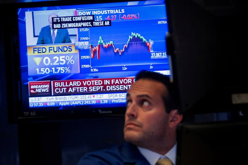 A screen displays the U.S. Federal Reserve interest rates announcement as traders work on the floor of the NYSE in New York