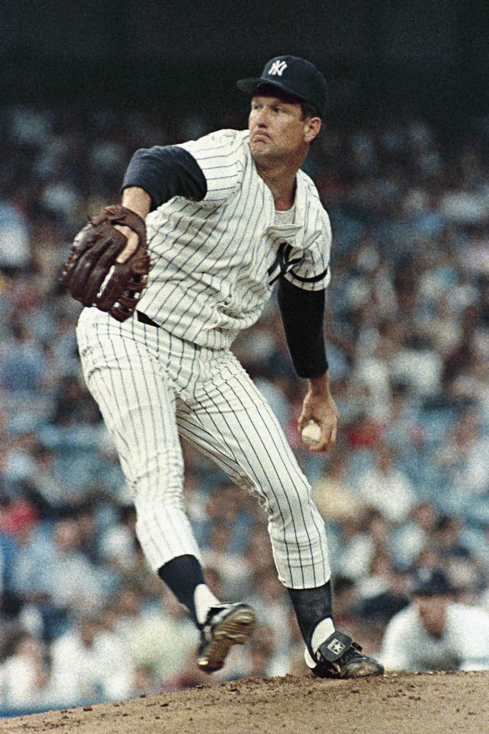 FILE - New York Yankees Tommy John pitches during a game against the Kansas City Royals at Yankee Stadium in New York, Aug. 8, 1986. Almost 50 years ago, on Sept. 25, 1974, Dr. Frank Jobe reconstructed a torn ulnar collateral ligament in John's left arm. It was a pioneering achievement for Jobe and a lifeline for John, who went from a career-ending injury to 14 more years in the majors — and an eponymous connection to sports medicine that would live on long past his playing days. Tommy John surgery.(AP Photo/Ron Frehm, File)