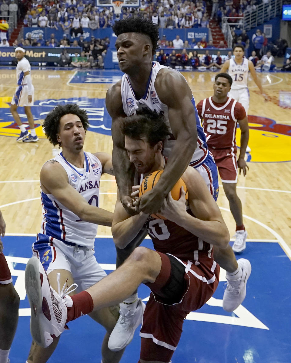 Oklahoma forward Sam Godwin, front, and Kansas forward K.J. Adams Jr., top, battle for a rebound during the first half of an NCAA college basketball game Tuesday, Jan. 10, 2023, in Lawrence, Kan. (AP Photo/Charlie Riedel)