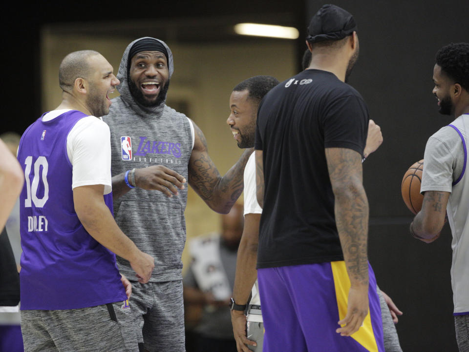 Los Angeles Lakers forward Jared Dudley, left, and James LeBron, second from left, smile during NBA basketball practice in El Segundo, Calif., Thursday, Jan. 30, 2020. The Lakers held their second practice while they continue to grieve for Kobe Bryant. The team held a light shooting workout Wednesday as they resumed basketball activities after the death of Bryant, his daughter Gianna, and seven others in a helicopter crash. (AP Photo/Damian Dovarganes)