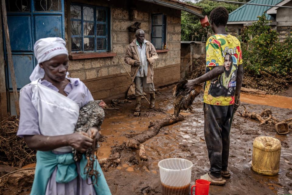 Members of a family gather some belonging after their house was flooded in an area heavily affected by torrential rains and flash floods in the village of Kamuchiri, near Mai Mahiu