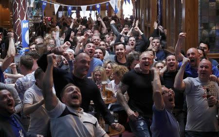 Leicester City fans react as their team scores a goal against Manchester United, as they watch the match in the Hogarth's pub in Leicester, Britain May 1, 2016 REUTERS/Eddie Keogh