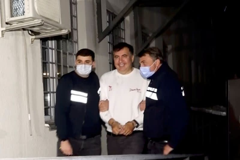 FILE PHOTO: Georgia's former President Mikheil Saakashvili is escorted by police officers as he arrives at a prison in Rustavi