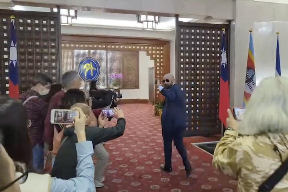 In this image taken from video by Taiwan's EBC, Harold Efrain Burgos Castro, Honduras Ambassador to Taiwan waves to journalists as he arrives at the Foreign Ministry in Taipei, Taiwan, Wednesday, March 15, 2023. Honduras President Xiomara Castro announced Tuesday that her government will seek to establish diplomatic relations with China, which would imply severing relations with Taiwan. The switch would leave Taiwan recognized by only 13 countries as China spends billions to win recognition for its "One China" policy. (EBC via AP )