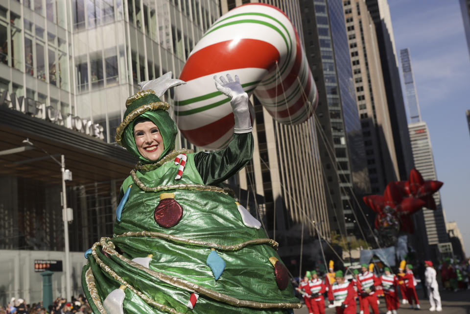 A parade performer in a Christmas Tree costume walks down Sixth Avenue during the Macy's Thanksgiving Day Parade, Thursday, Nov. 24, 2022, in New York. (AP Photo/Jeenah Moon)