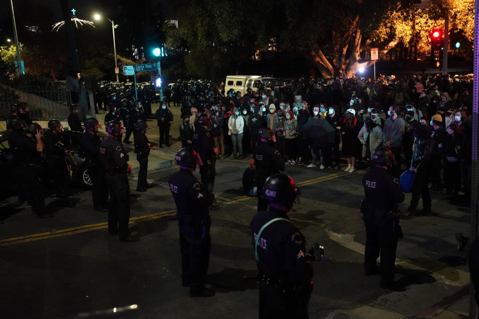 Demonstrators face off with police during a protest in the Echo Park section of Los Angeles Thursday, March 25, 2021. Demonstrators gathered Wednesday night to protest the planned temporary closure of a Los Angeles park that would displace a large homeless encampment, which has grown throughout the coronavirus pandemic. (AP Photo/Marcio Jose Sanchez)