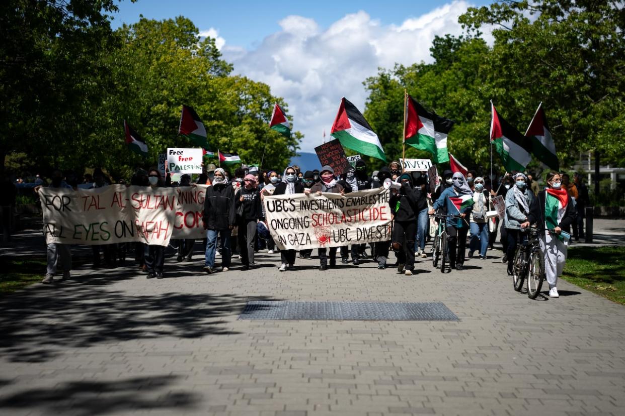 Pro-Palestinian protesters march during a demonstration at the rose garden at the University of British Columbia. (Ethan Cairns/CBC - image credit)