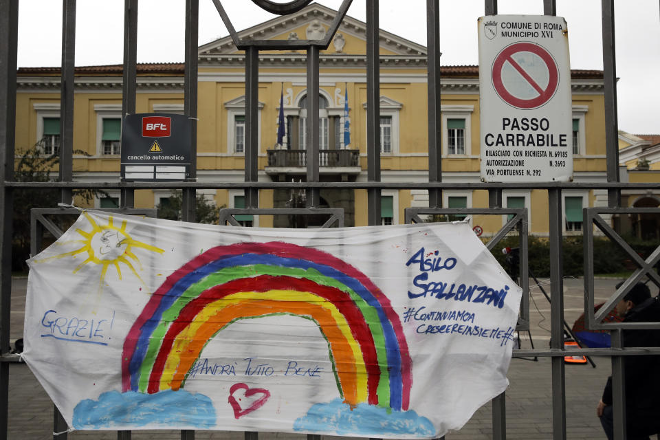 In this photo taken on Saturday, March 14, 2020, a banner reading "Everything will be alright" hangs on the main gate of the Spallanzani Hospital for Infectious Diseases, the Italian main hub for coronavirus treatment, in Rome, Saturday, March 14, 2020. The nationwide lockdown to slow coronavirus is still early days for much of Italy, but Italians are already are showing signs of solidarity. This week, children’s drawings of rainbows are appearing all over social media as well as on balconies and windows in major cities ready, ‘’Andra’ tutto bene,’’ Italian for ‘’Everything will be alright.’’ For most people, the new coronavirus causes only mild or moderate symptoms. For some, it can cause more severe illness, especially in older adults and people with existing health problems. (AP Photo/Alessandra Tarantino)