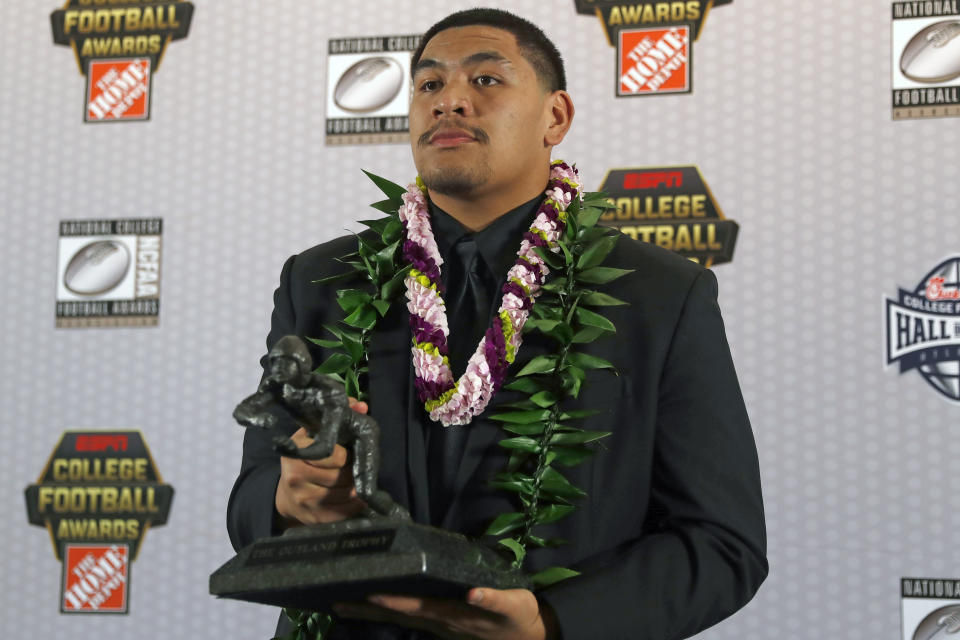 FILE - In this Dec. 12, 2019, file photo, Oregon's Penei Sewell poses with Outland Trophy for being the nation's best interior lineman, in Atlanta. Sewell is a likely first round pick in the NFL Draft, April 29-May 1, 2021, in Cleveland.(AP Photo/John Bazemore, File)