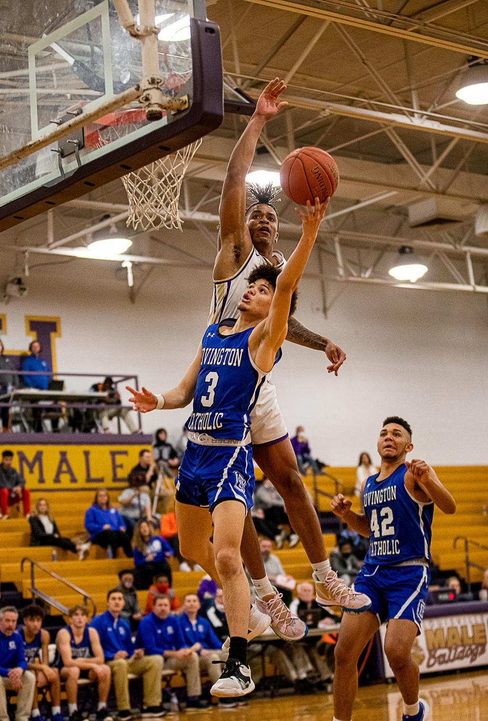 Male's Kaleb Glenn (1) rose to block a shot by Covington Catholic's James Wilson (3) during first half action Saturday afternoon at the Male High School gym. The Bulldogs went on to beat the Colonels, 73-68. January 22, 2022