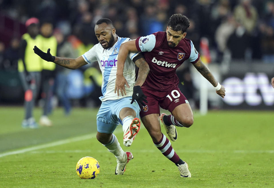 Crystal Palace's Jordan Ayew and West Ham United's Lucas Paqueta, right, battle for the ball during the English Premier League soccer match between Crystal Palace and West Ham United at the London Stadium in London, Sunday Dec. 3, 2023. (Zac Goodwin/PA via AP)