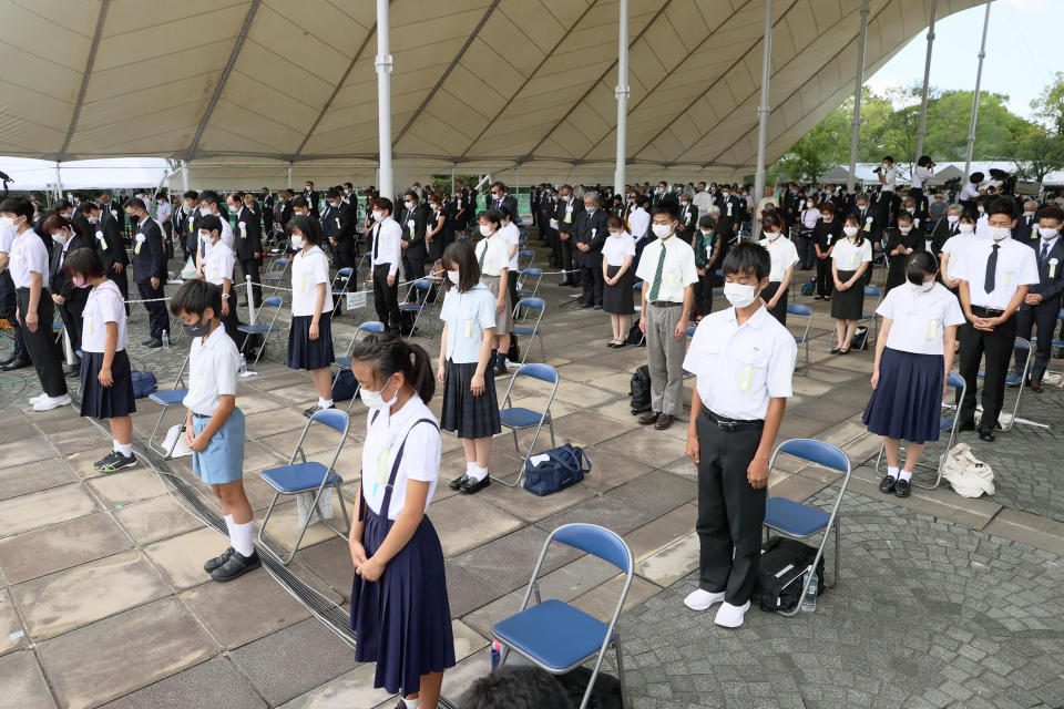 Attendees offer a silent prayer during a ceremony at Nagasaki Peace Park in Nagasaki, southern Japan Monday, Aug. 9, 2021. The Japanese city of Nagasaki on Monday marked its 76th anniversary of the U.S. atomic bombing. (Kyodo News via AP)